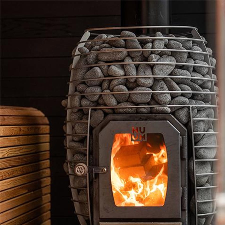 HUUM Hive Wood 17 wood-burning sauna heater with visible flames and stone surround