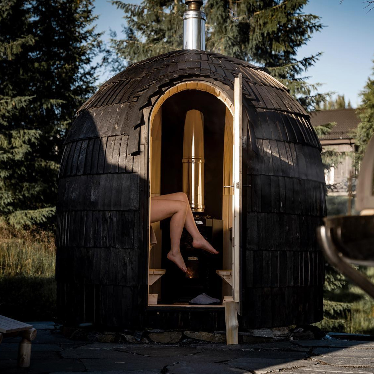Round outdoor wood burning sauna in a snowy landscape - Iglucraft Single Sauna
