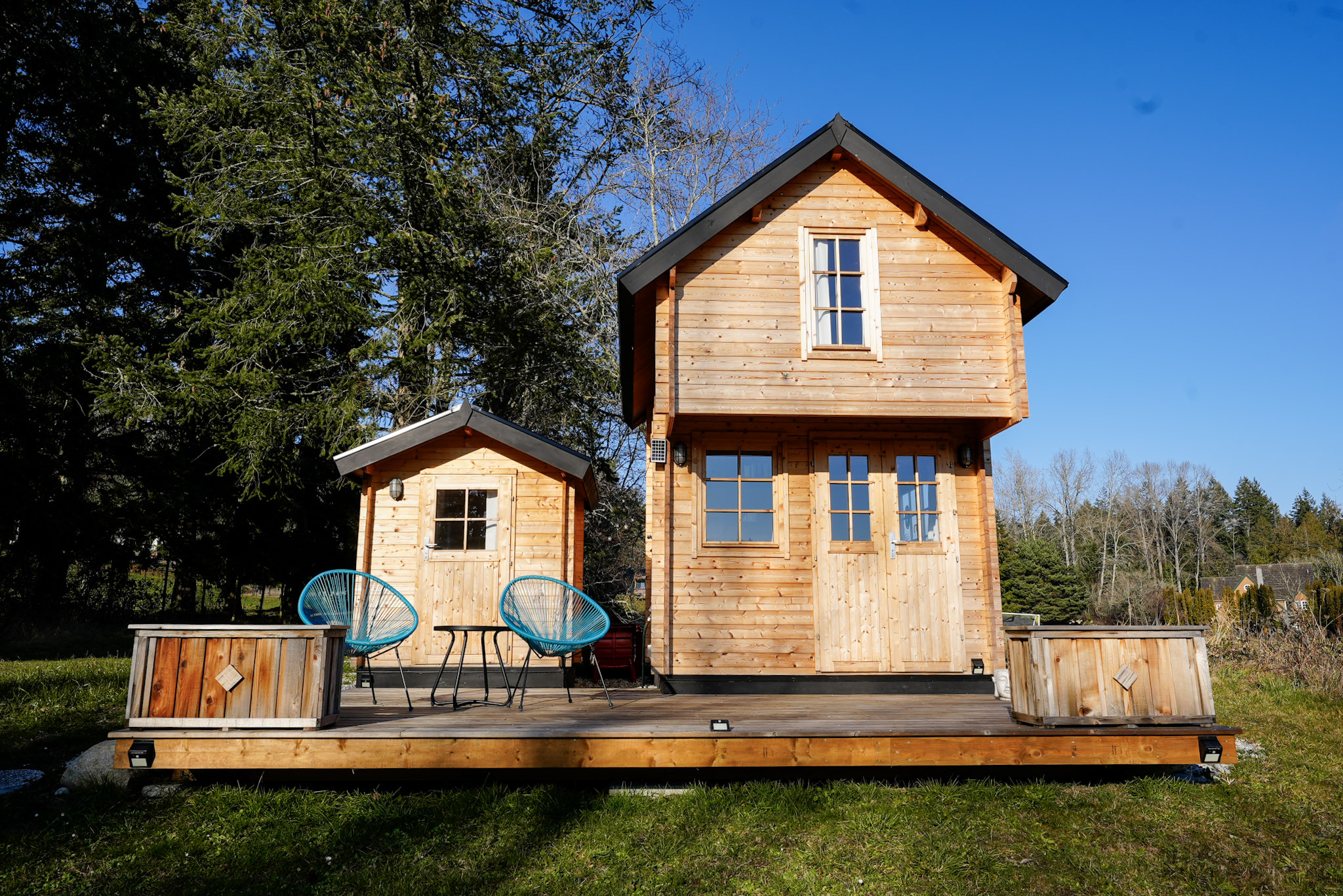 Compact wooden shed next to bunkie structure for backyard or cabin property use