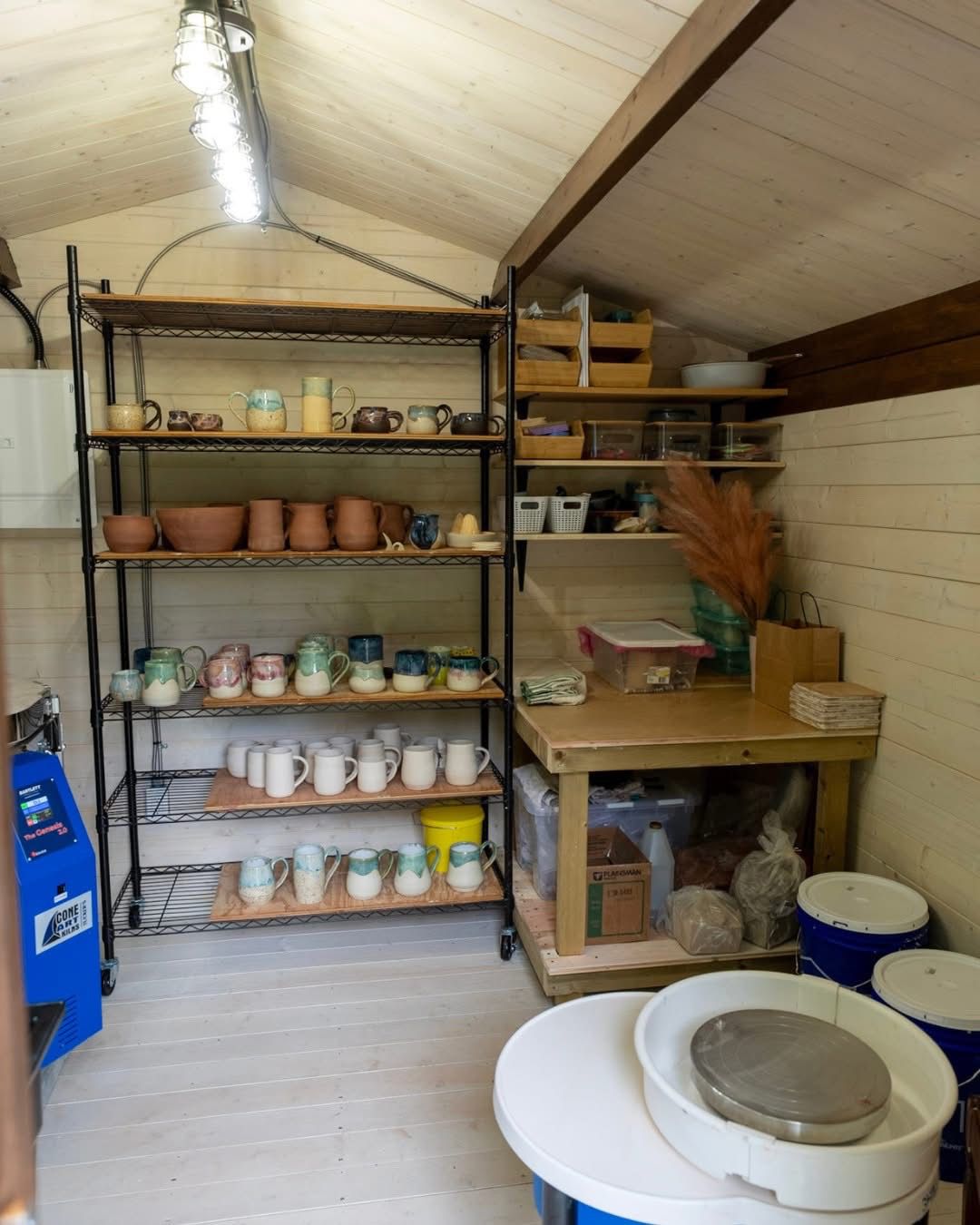 DIY shed used as a pottery studio with workspace and shelves