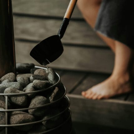 Cedar sauna accessory kit including bucket, ladle, sand timer, and thermometer on bench