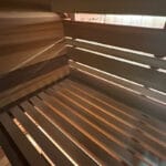 Handmade cedar door with window leading into insulated sauna cabin