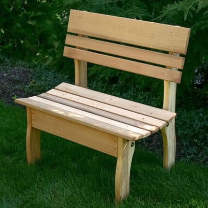 Red Cedar Chickadee Backed Bench in landscape setting, highlighting sun-kissed sheen and avian-inspired backing as a charming cedar bench for verandas or trails