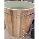 Athlete recovering in a PVC barrel cold plunge tub