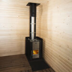 Wood-burning sauna stove with glass door and stone basket