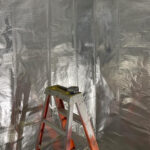 Man installing vapor barrier on wall