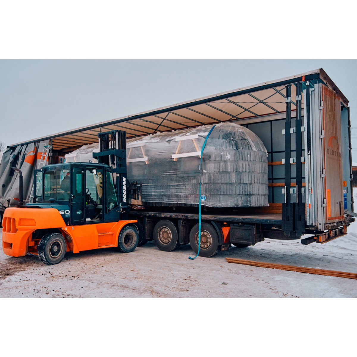 Forklift preparing to unload an Iglucraft sauna from a flatbed semi truck