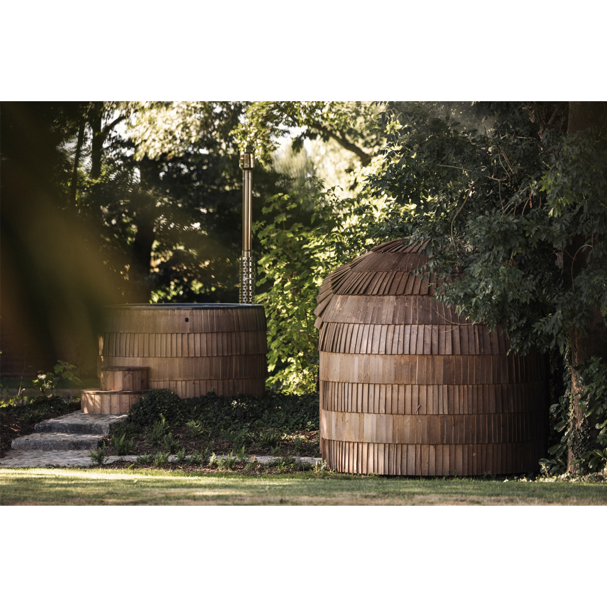 Wood fired hot tub next to sauna in winter setting
