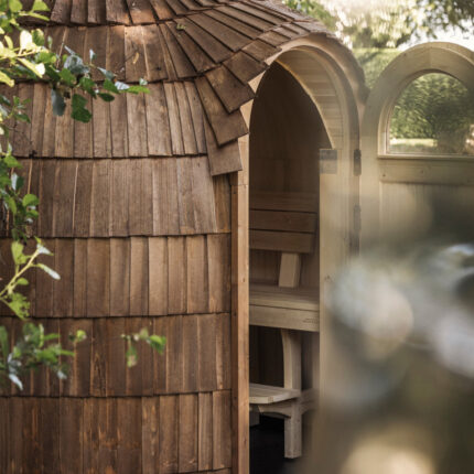 Outdoor wood burning sauna in a snowy forest setting