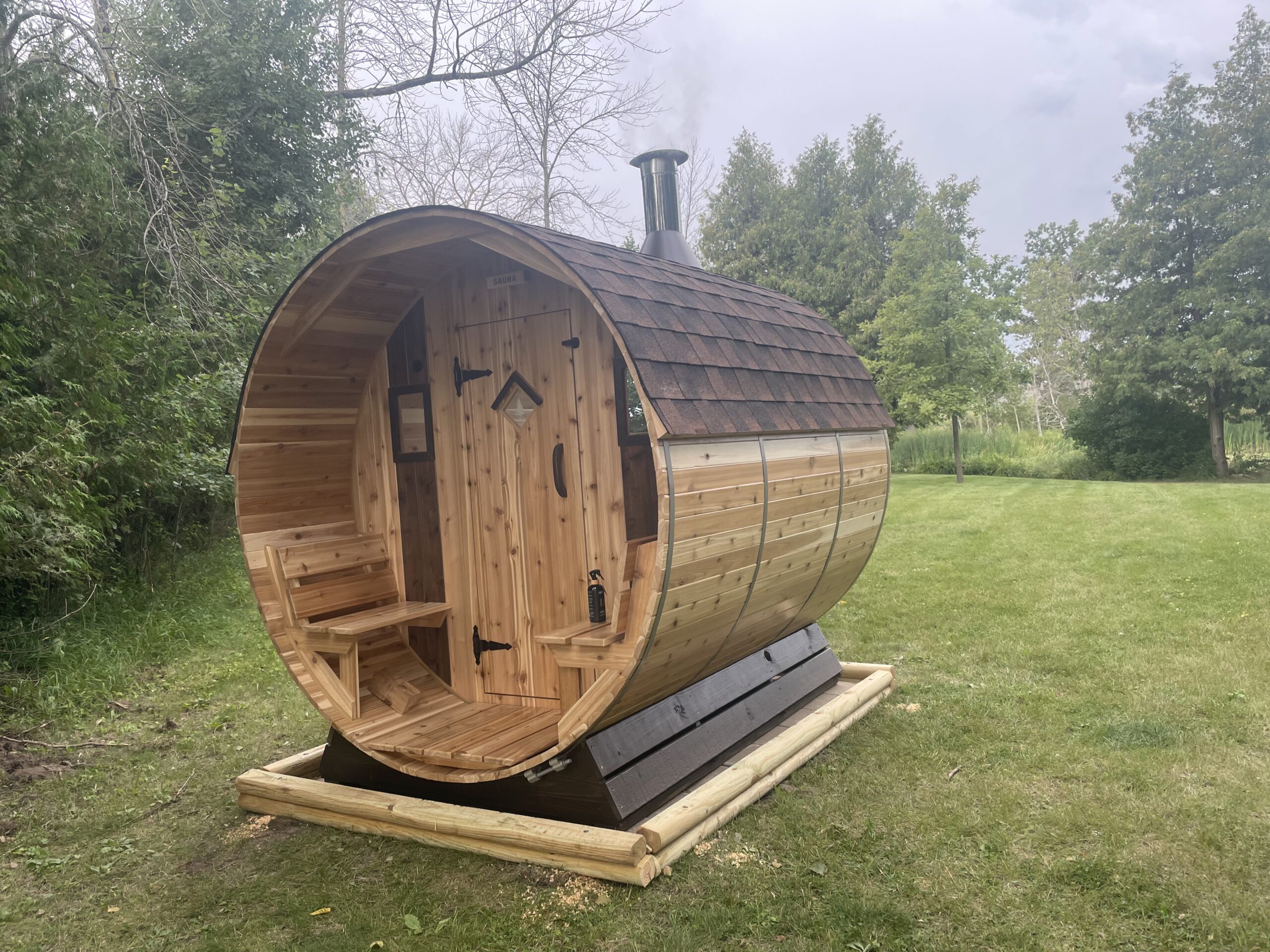 7' x 8' 6-Person Wood Fired Sauna with Front Porch – Cedar Sense signature outdoor sauna featuring covered porch and authentic cedar barrel design