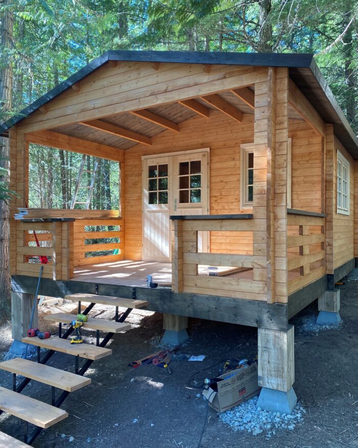 Fireplace setup on the covered porch of a tiny cabin
