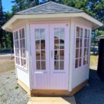 Pink DIY gazebo with white trim for garden retreat