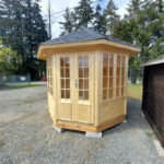 Blue DIY gazebo with tan trim for backyard studio use