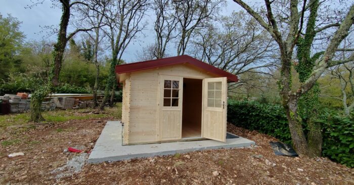 DIY shed assembly step with wall boards being installed