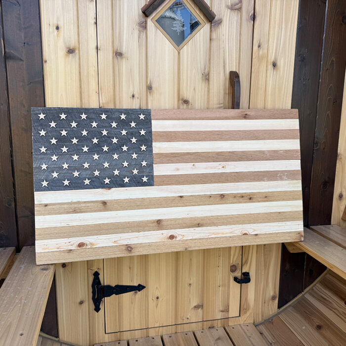 Close up of natural wooden sauna flag with laser cut stars nailed in place