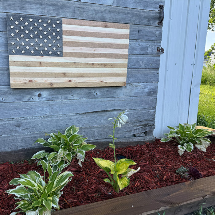 Natural unfinished wooden American flag for sauna decor and rustic cabin spaces
