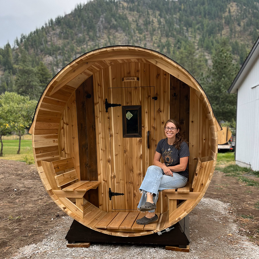 Kate sitting on the porch of her Cedar Sense barrel sauna at Blackfoot River House