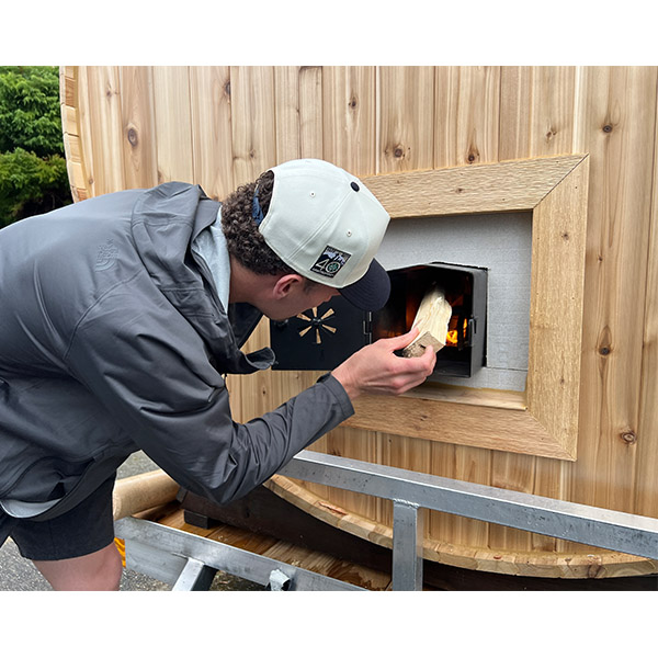 Matthew lighting the sauna stove for the first time
